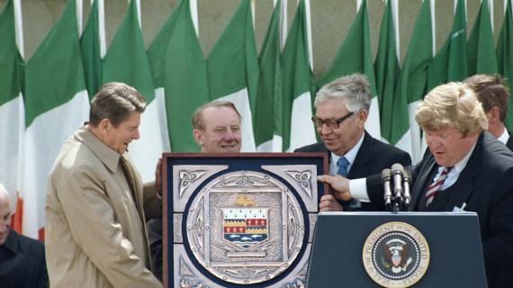 President Ronald Reagan being presented with coat of arms by Edmond Brennan in the village square in Ballyporeen, Ireland, 06/03/1984